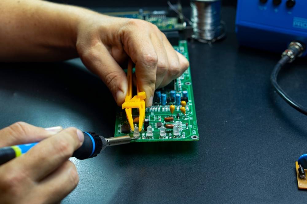 Hands,Of,The,Master,,Soldering,Iron,And,Electronic,Board,On